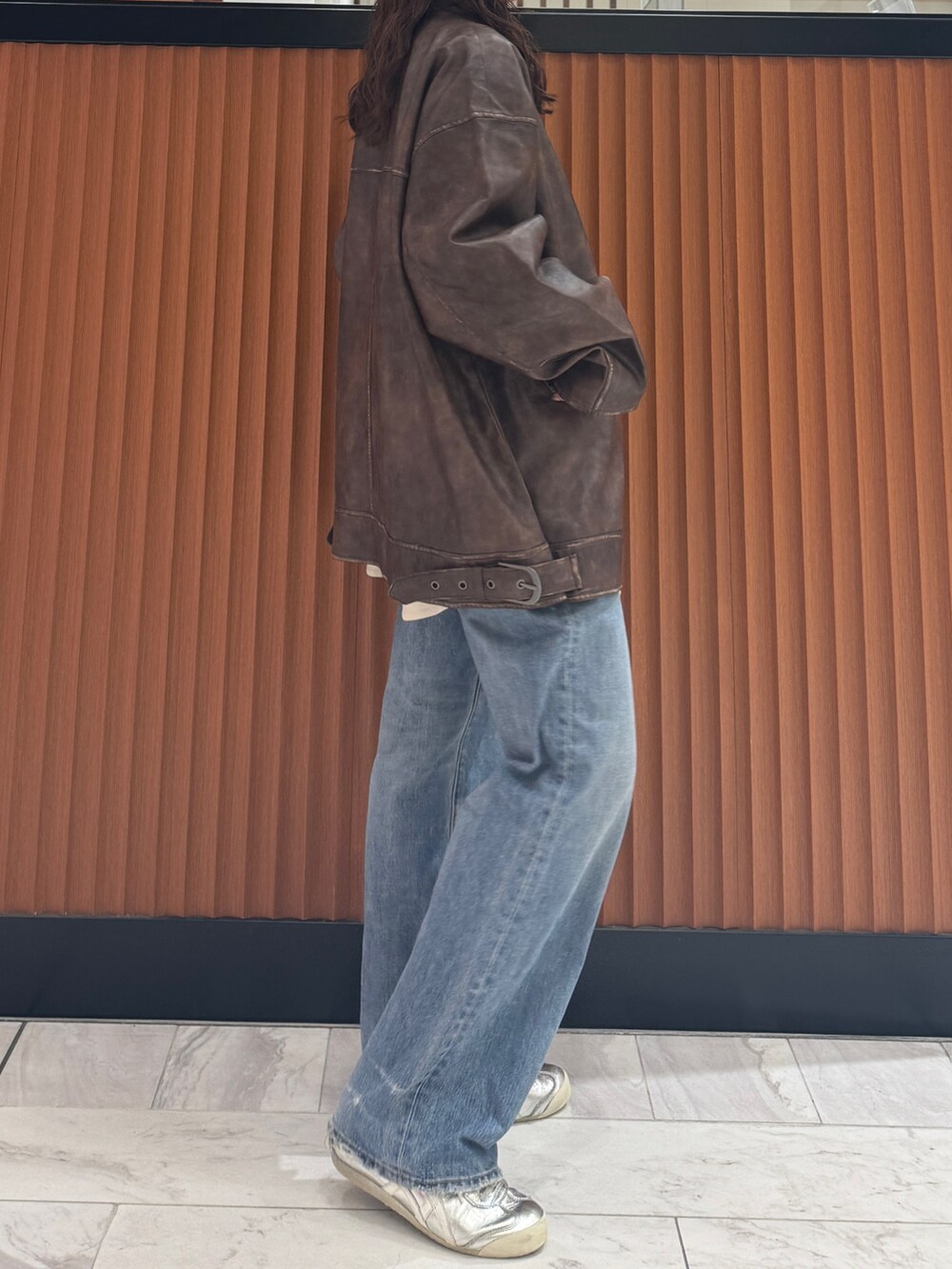 ブラウン系のブルゾン、ホワイト系のシャツ/ブラウス、ブルー系のデニムパンツを着用したレディースの秋コーディネートの2枚目の写真