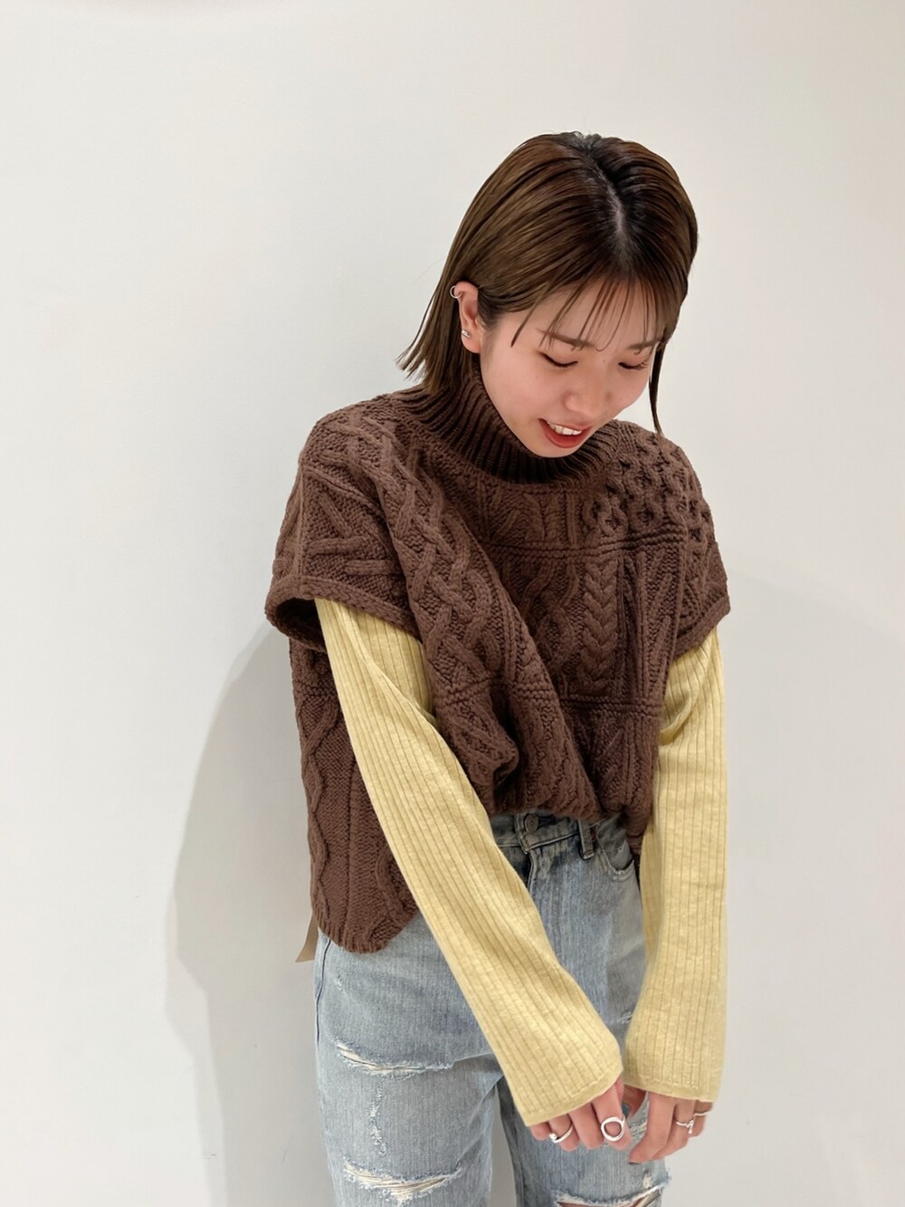 ブラウン系のニット/セーター、ブルー系のデニムパンツ、ブラック系のブーツを着用したレディースの冬コーディネートの9枚目の写真