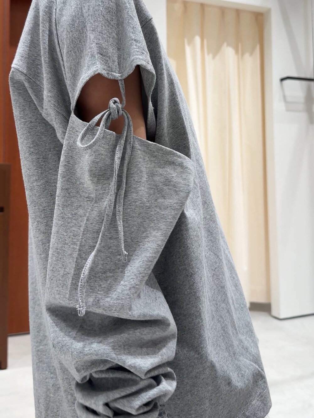 ホワイト系のワンピース、グリーン系のミリタリージャケット、グレー系のTシャツ/カットソーを着用したレディースの春コーディネートの6枚目の写真