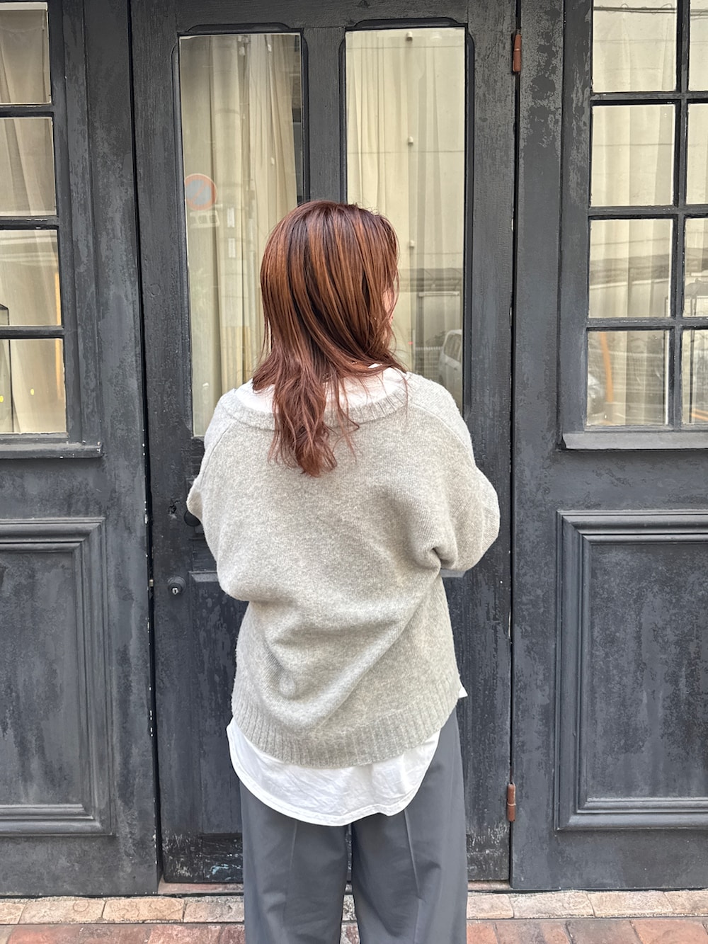 グレー系のニット/セーター、ホワイト系のTシャツ/カットソー、グレー系のその他パンツを着用したレディースの冬コーディネートの9枚目の写真