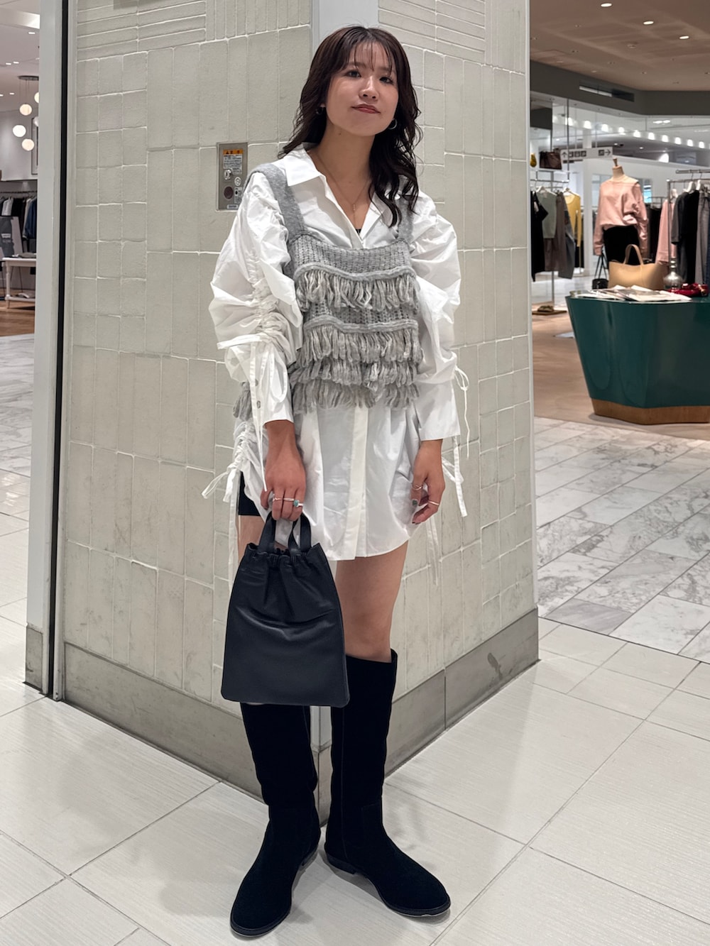 ホワイト系のシャツ/ブラウス、ブルー系のニット/セーター、ブラック系のショルダーバッグを着用したレディースの秋コーディネートの10枚目の写真