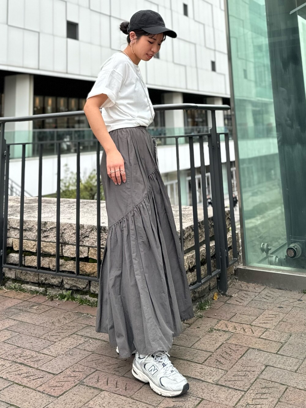 シルバー系のショルダーバッグ、ホワイト系のTシャツ/カットソー、グレー系のスカートを着用したレディースの春コーディネートの5枚目の写真