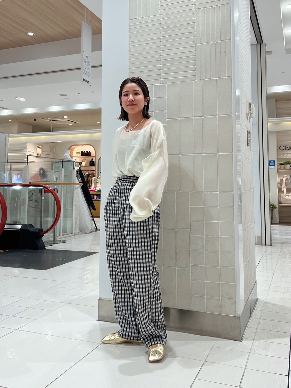 イエロー系のニット/セーター、イエロー系のパンプス、グレー系のその他パンツを着用したレディースの冬コーディネートの2枚目の写真