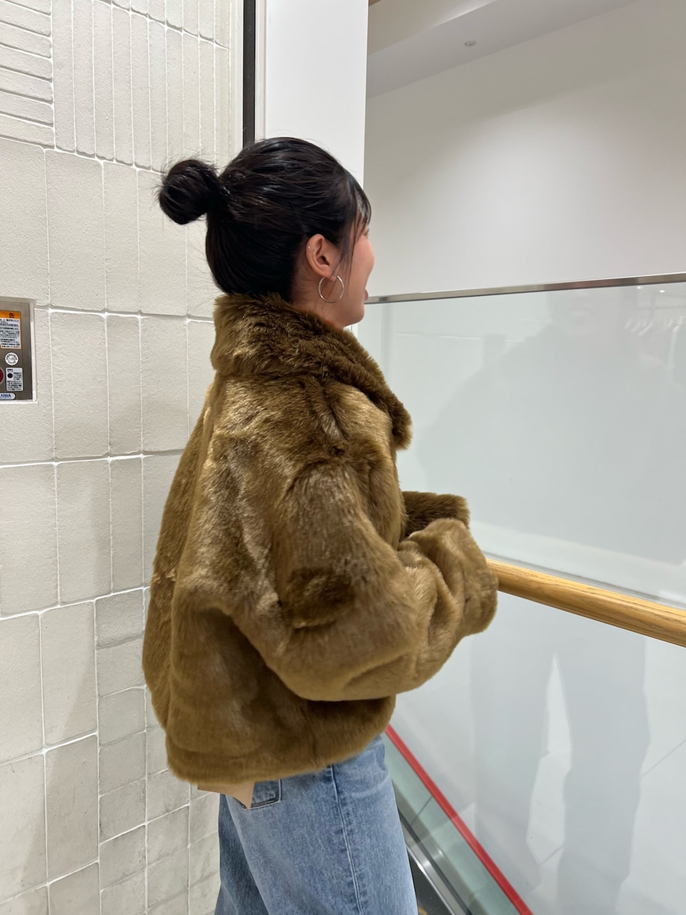 ブルー系のデニムパンツ、ブラウン系のブルゾン、レッド系のニット/セーターを着用したレディースの冬コーディネートの3枚目の写真