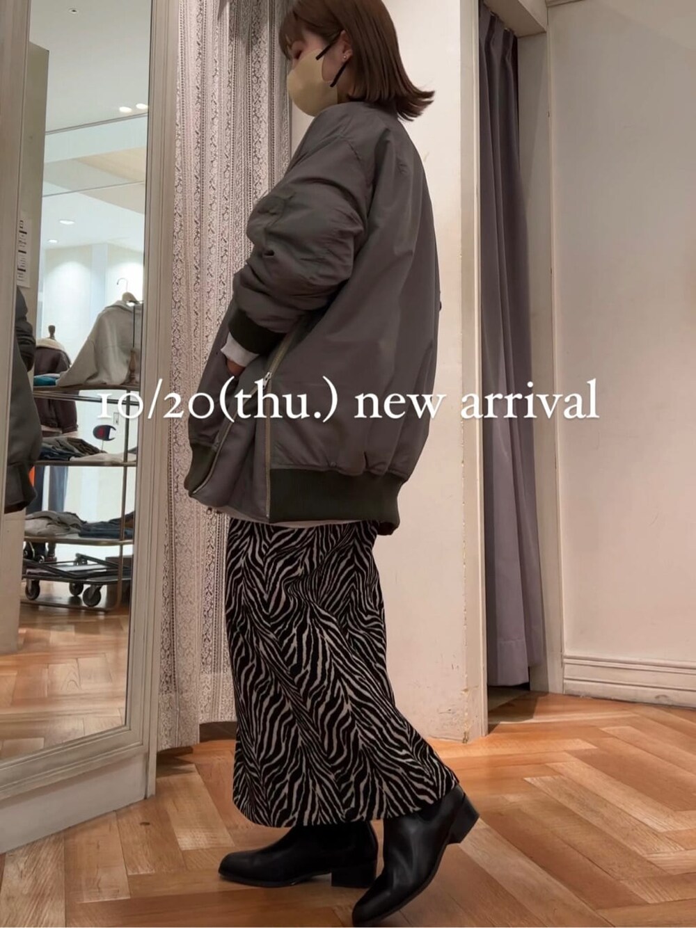 グレー系のスウェット、グリーン系のMA-1、ブラック系のスカートを着用したレディースの秋コーディネートの2枚目の写真