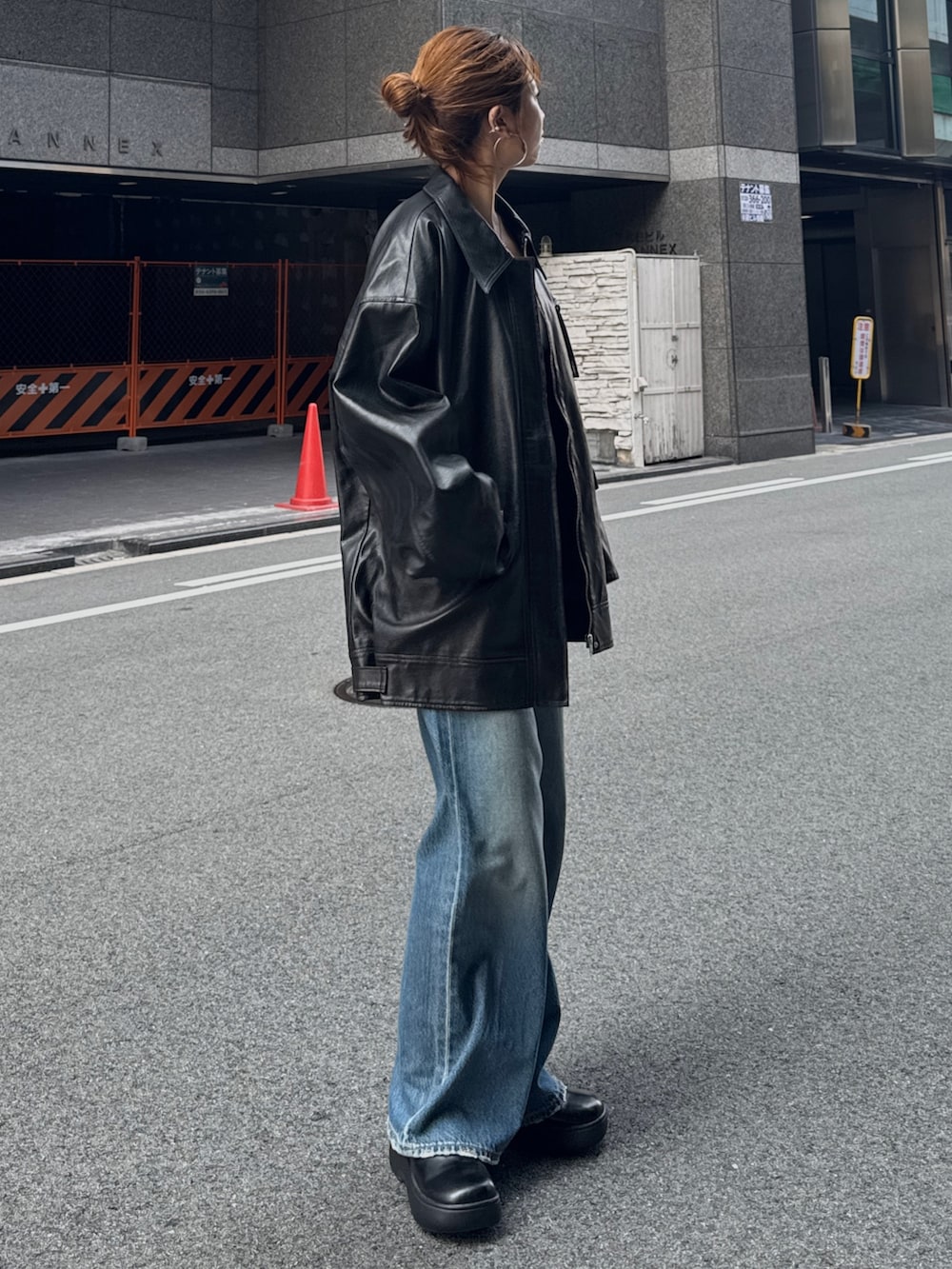 ブラック系のブルゾン、ブルー系のデニムパンツを着用したレディースの秋コーディネートの7枚目の写真