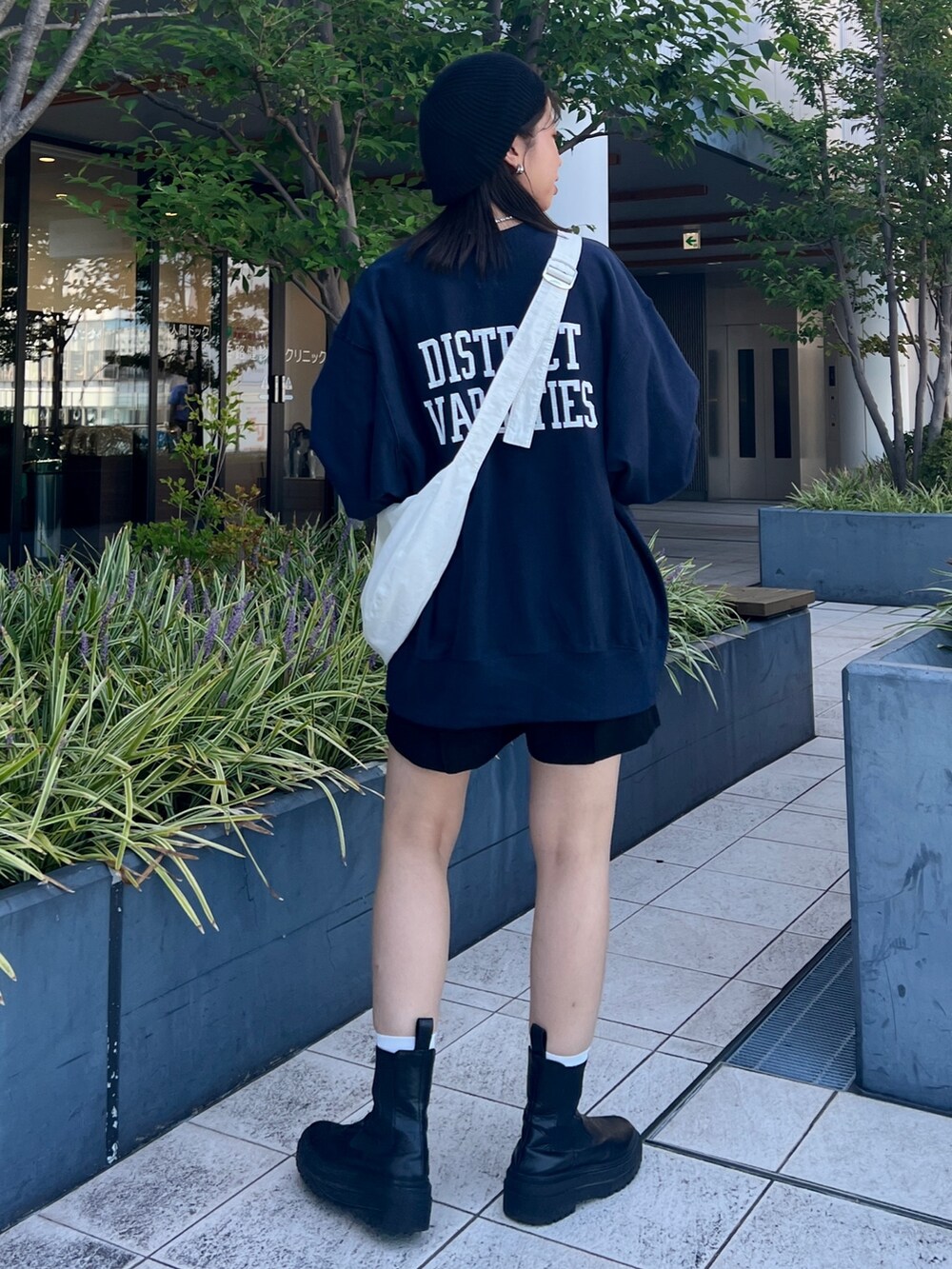 ブルー系のスウェット、ホワイト系のショルダーバッグ、ブラック系のハンチング/ベレー帽を着用したレディースの秋コーディネートの5枚目の写真