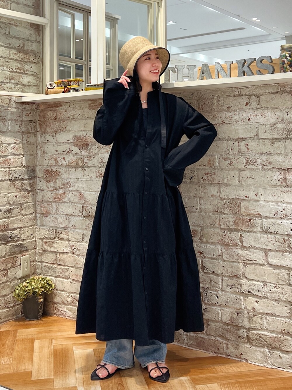 ブルー系のデニムパンツ、ブラック系のサンダル、ブラック系のワンピースを着用したレディースの春コーディネートの5枚目の写真