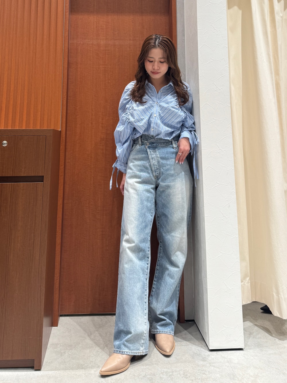 ブルー系のシャツ/ブラウス、ブルー系のデニムパンツ、ベージュ系のブーツを着用したレディースの春コーディネートの7枚目の写真