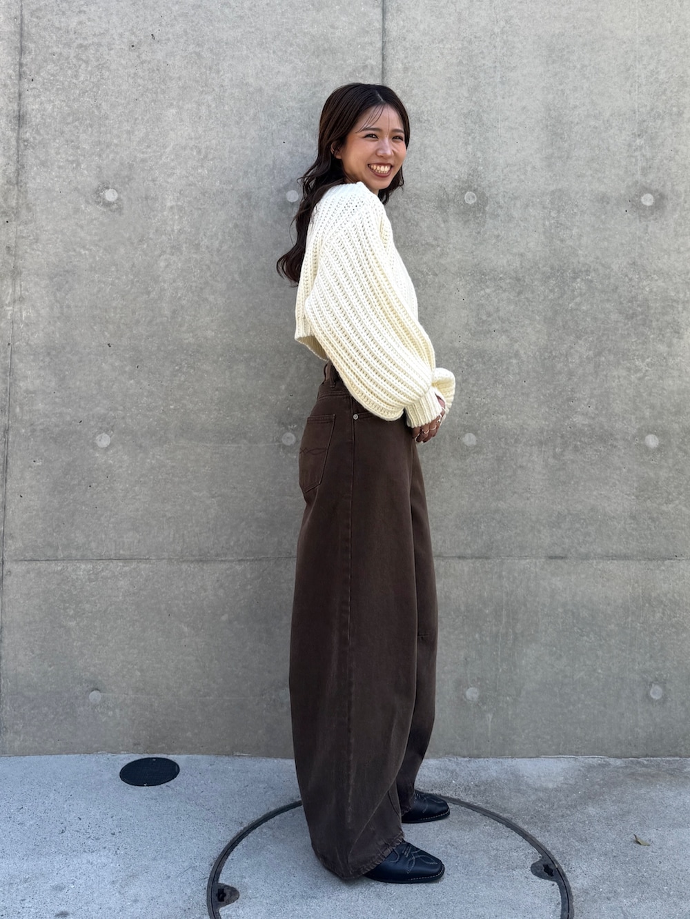 ブラック系のその他シューズ、ブラウン系のデニムパンツ、ホワイト系のニット/セーターを着用したレディースの秋コーディネートの6枚目の写真