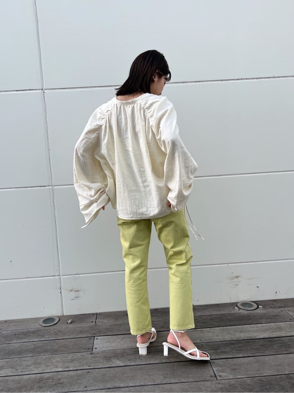 グリーン系のデニムパンツ、ホワイト系のシャツ/ブラウス、ホワイト系のサンダルを着用したレディースの春コーディネートの4枚目の写真