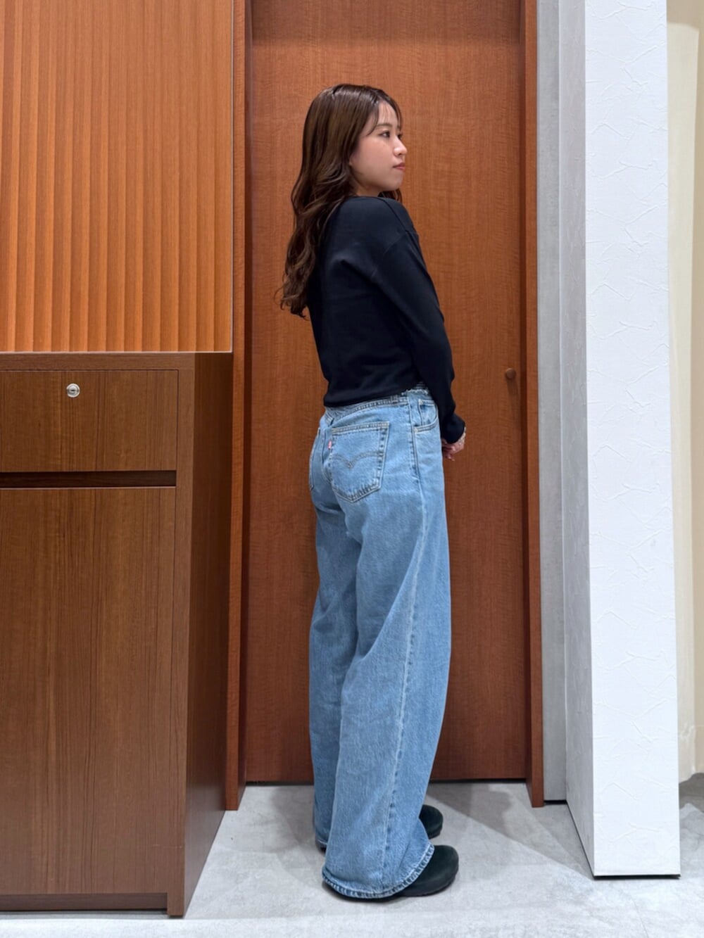 ブルー系のデニムパンツ、ブラック系のTシャツ/カットソー、シルバー系のネックレスを着用したレディースの夏コーディネートの2枚目の写真