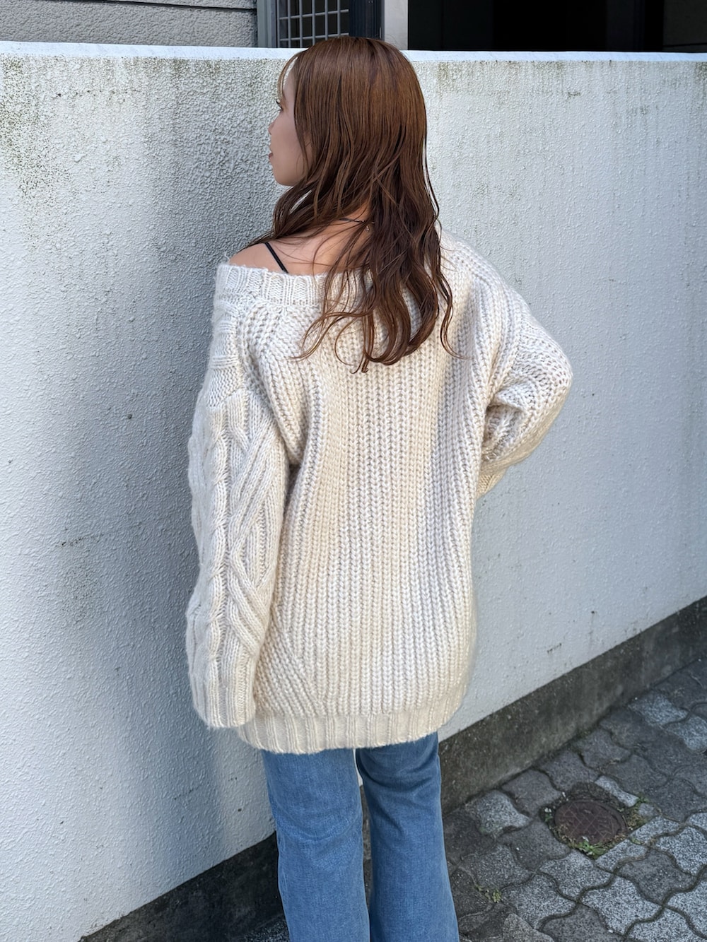 ホワイト系のニット/セーター、ブルー系のデニムパンツ、シルバー系のその他シューズを着用したレディースの夏コーディネートの9枚目の写真