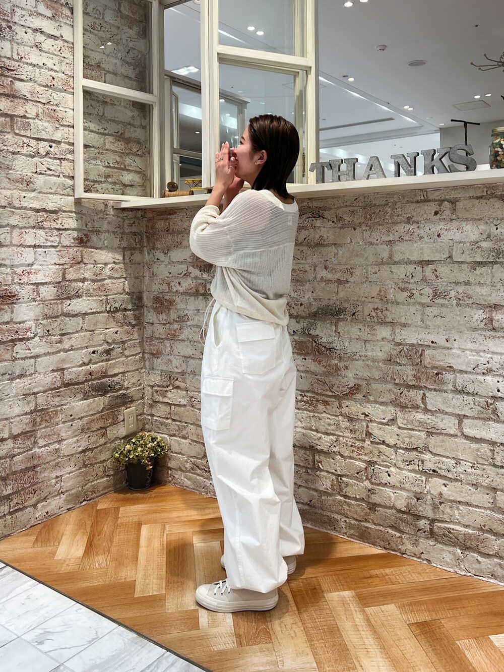 ホワイト系のカーゴパンツ、ホワイト系のカーディガン/ボレロ、ホワイト系のスニーカーを着用したレディースの春コーディネートの5枚目の写真