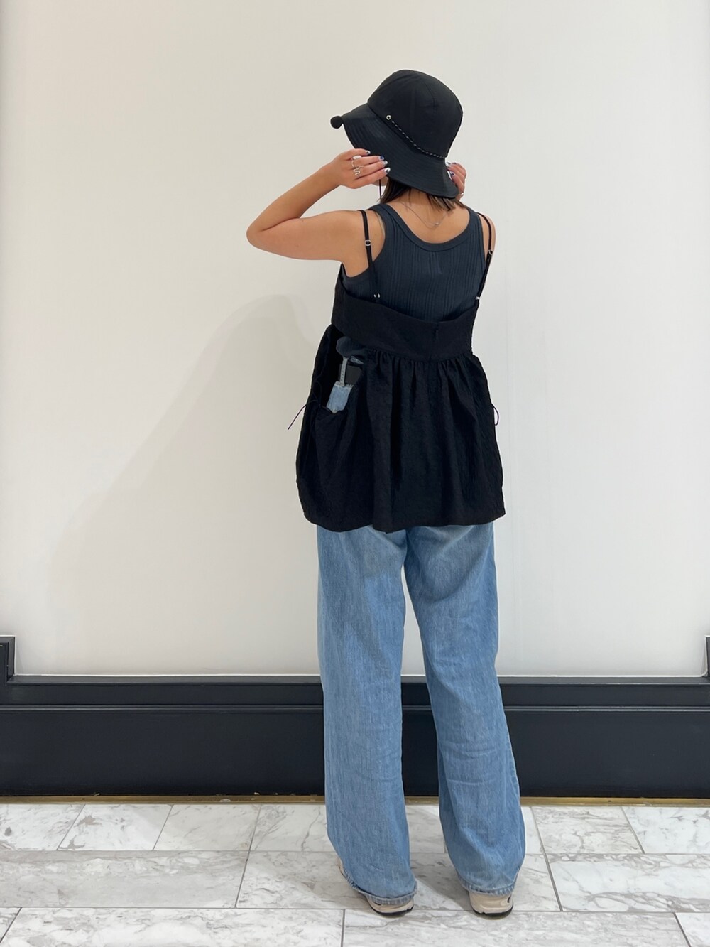 グレー系のタンクトップ、ブルー系のデニムパンツ、ブラック系のシャツ/ブラウスを着用したレディースの春コーディネートの6枚目の写真