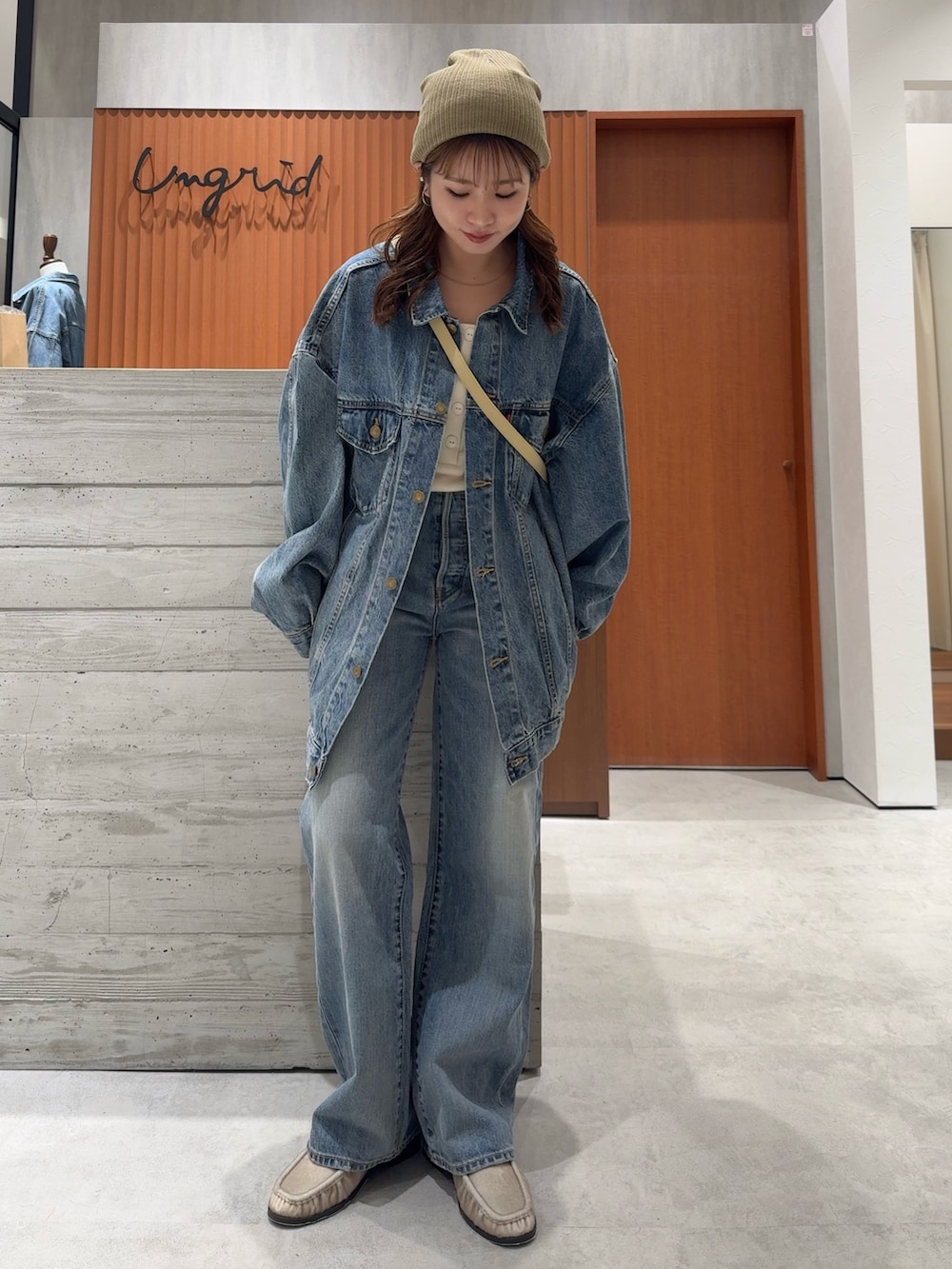 ブルー系のデニムジャケット、ブルー系のデニムパンツ、ホワイト系のタンクトップを着用したレディースの夏コーディネートの6枚目の写真