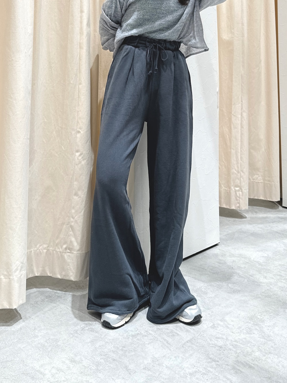 グレー系のニット/セーター、グリーン系のTシャツ/カットソー、グレー系のスウェットパンツを着用したレディースの秋コーディネートの3枚目の写真