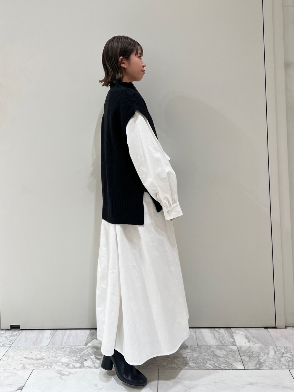 ブラック系のニット/セーター、ブラック系のワンピース、ブラック系のブーツを着用したレディースの冬コーディネートの3枚目の写真