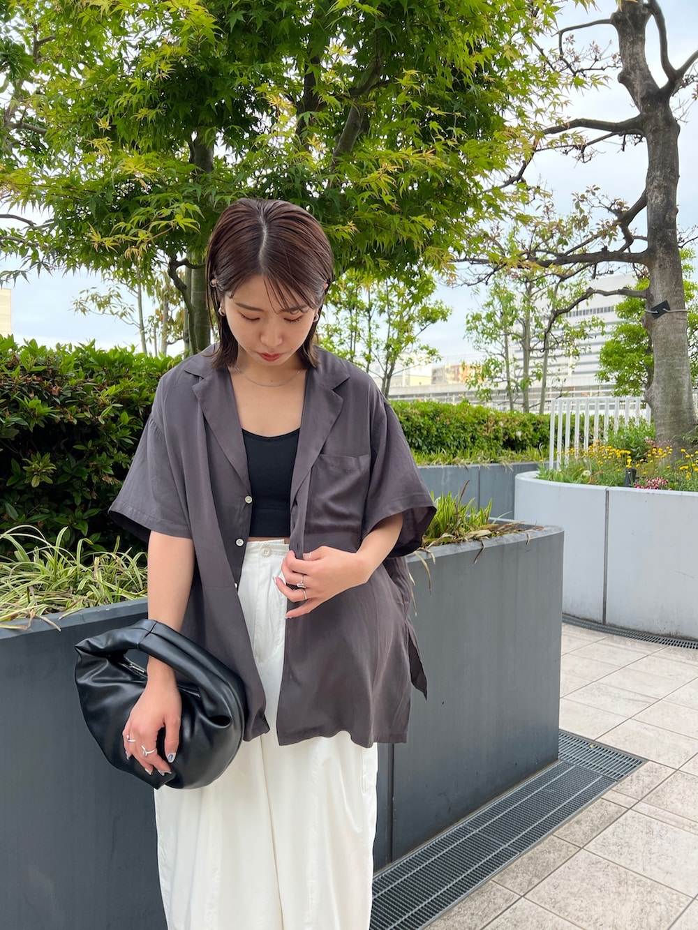 グレー系のシャツ/ブラウス、ブラック系のキャミソール、ホワイト系のカーゴパンツを着用したレディースの春コーディネートの7枚目の写真