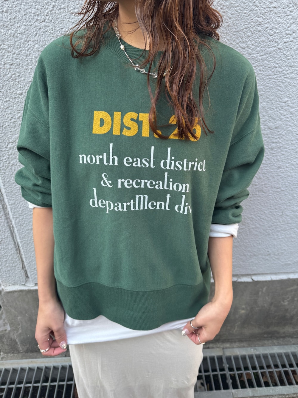 ホワイト系のスカート、ブラウン系のブルゾン、グリーン系のスウェットを着用したレディースの冬コーディネートの9枚目の写真