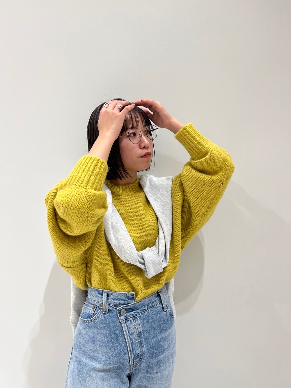 ブルー系のデニムパンツ、イエロー系のニット/セーター、グレー系のスウェットを着用したレディースの冬コーディネートの8枚目の写真