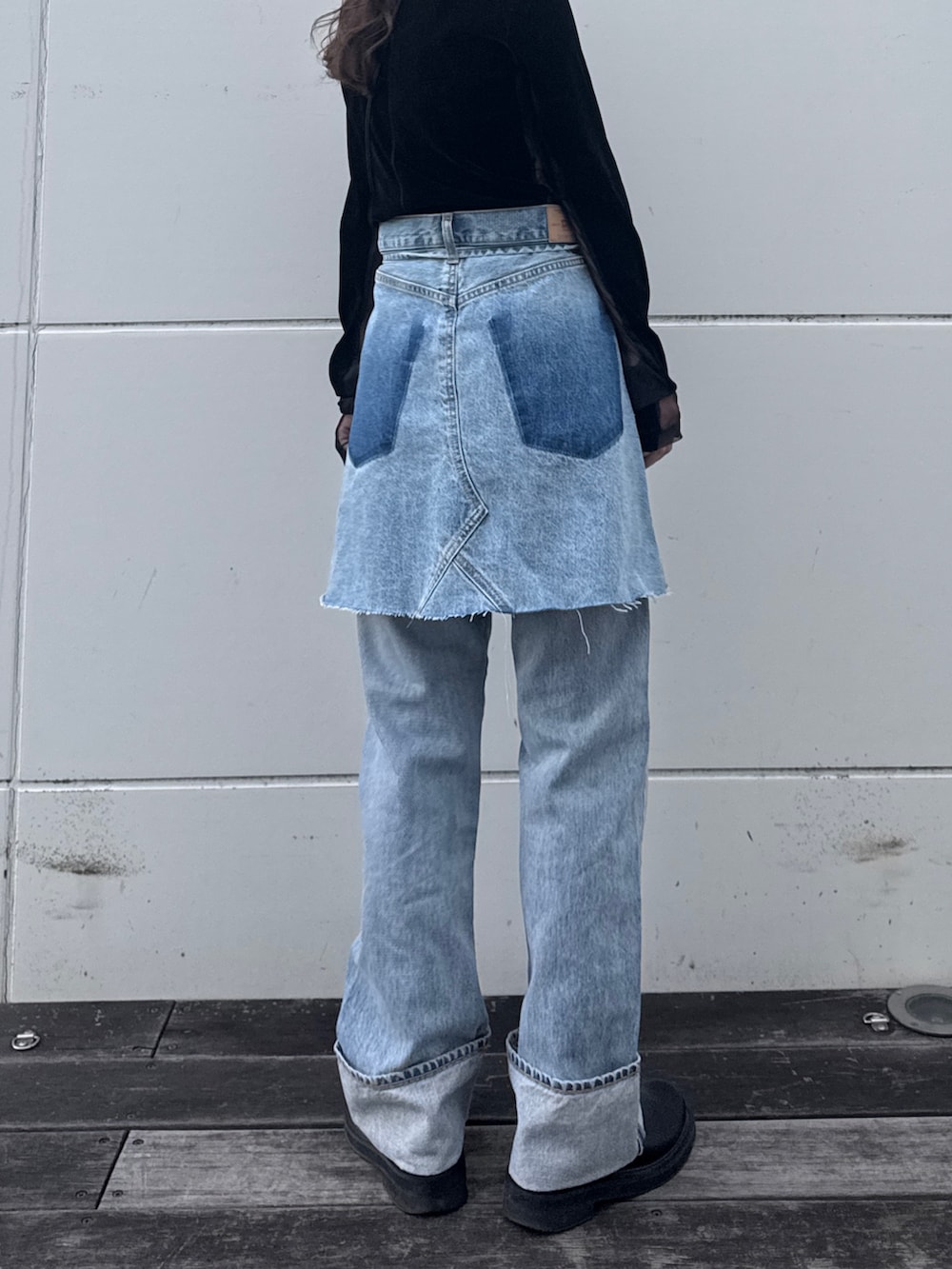 ブラック系のTシャツ/カットソー、ブルー系のスカート、ブルー系のデニムパンツを着用したレディースの冬コーディネートの4枚目の写真