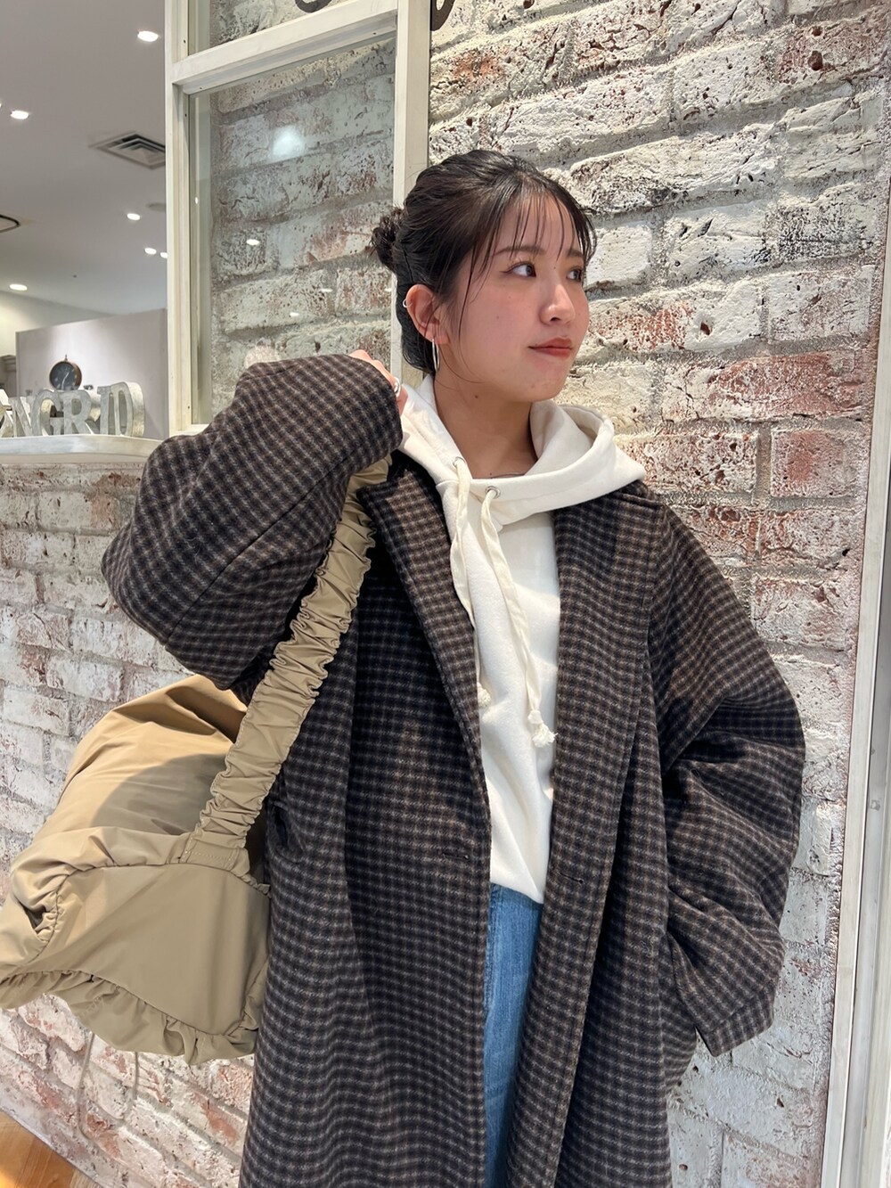 ベージュ系のブーツ、ブルー系のデニムパンツ、その他のチェスターコートを着用したレディースの冬コーディネートの2枚目の写真