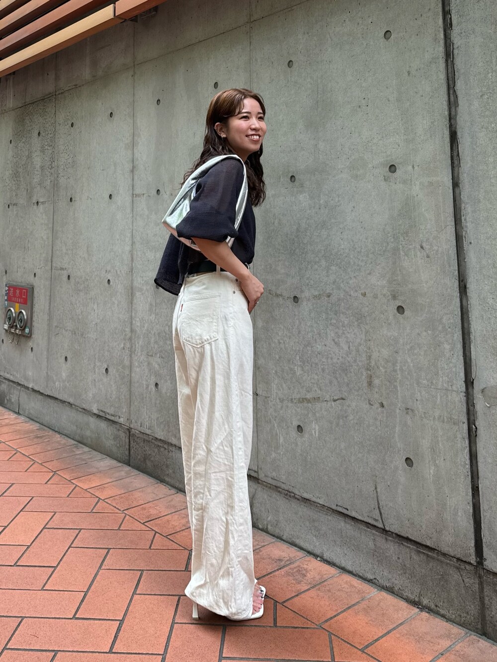 シルバー系のハンドバッグ、ホワイト系のデニムパンツ、グレー系のTシャツ/カットソーを着用したレディースの夏コーディネートの9枚目の写真