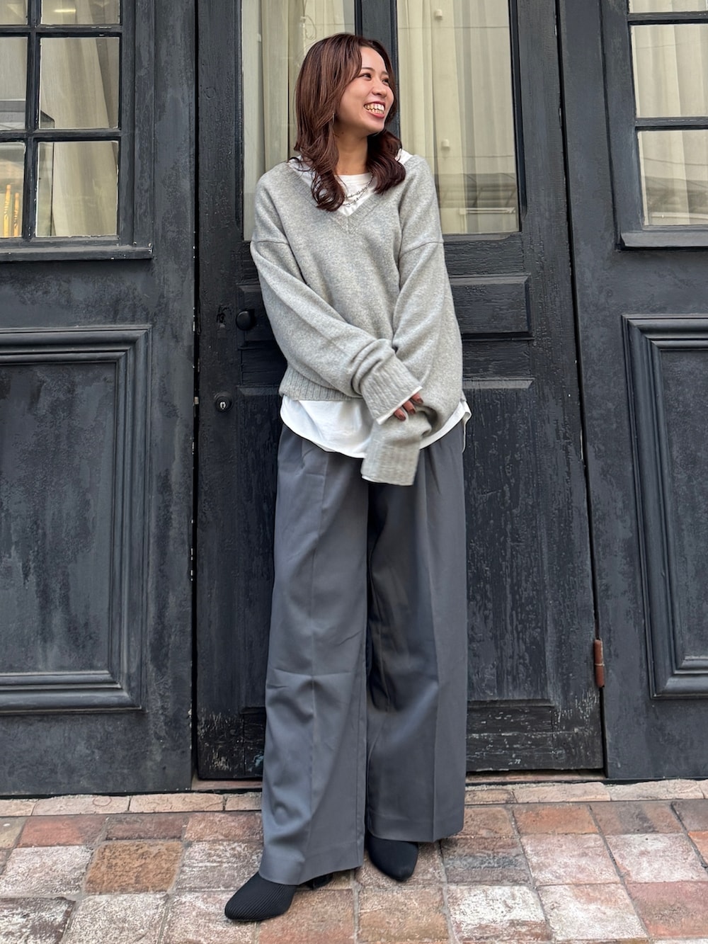 グレー系のニット/セーター、ホワイト系のTシャツ/カットソー、グレー系のその他パンツを着用したレディースの冬コーディネートの7枚目の写真