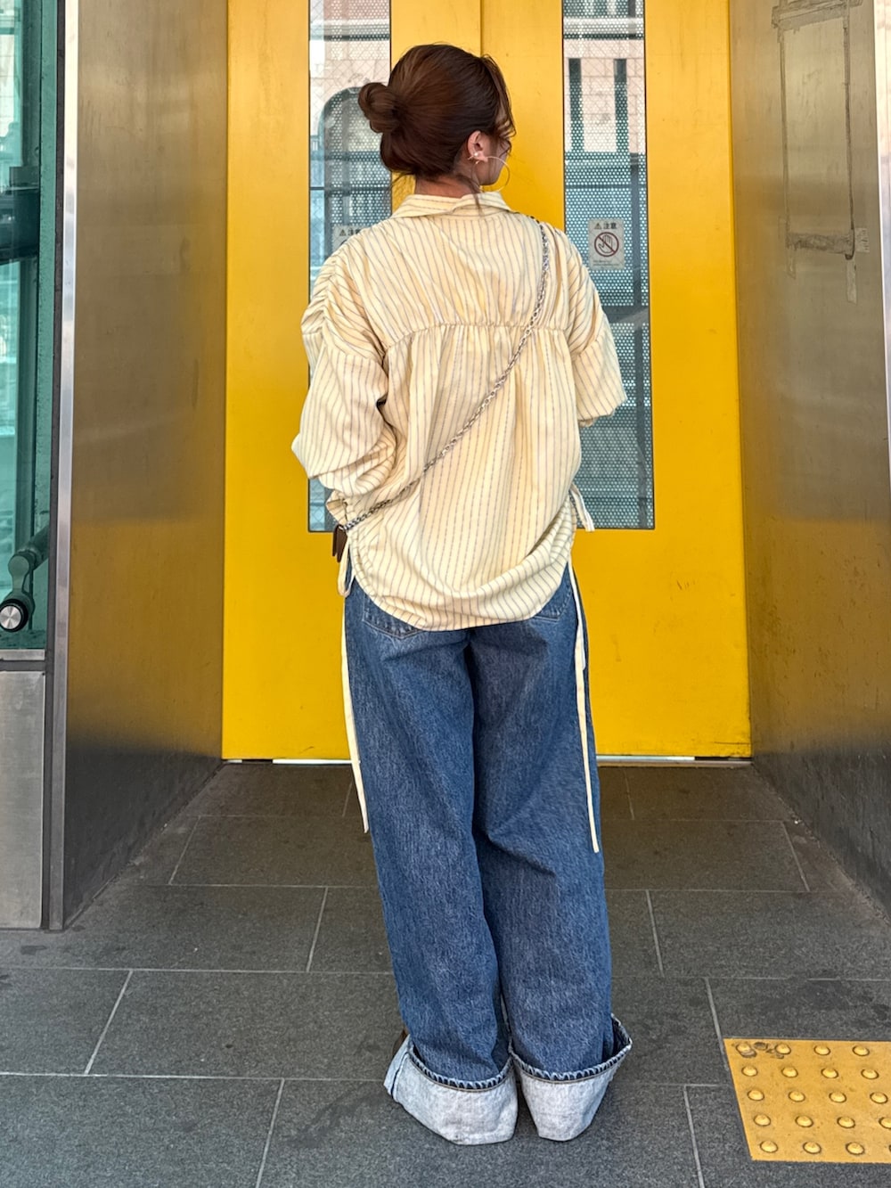 イエロー系のシャツ/ブラウス、ブルー系のデニムパンツ、ブラウン系のローファーを着用したレディースの冬コーディネートの4枚目の写真