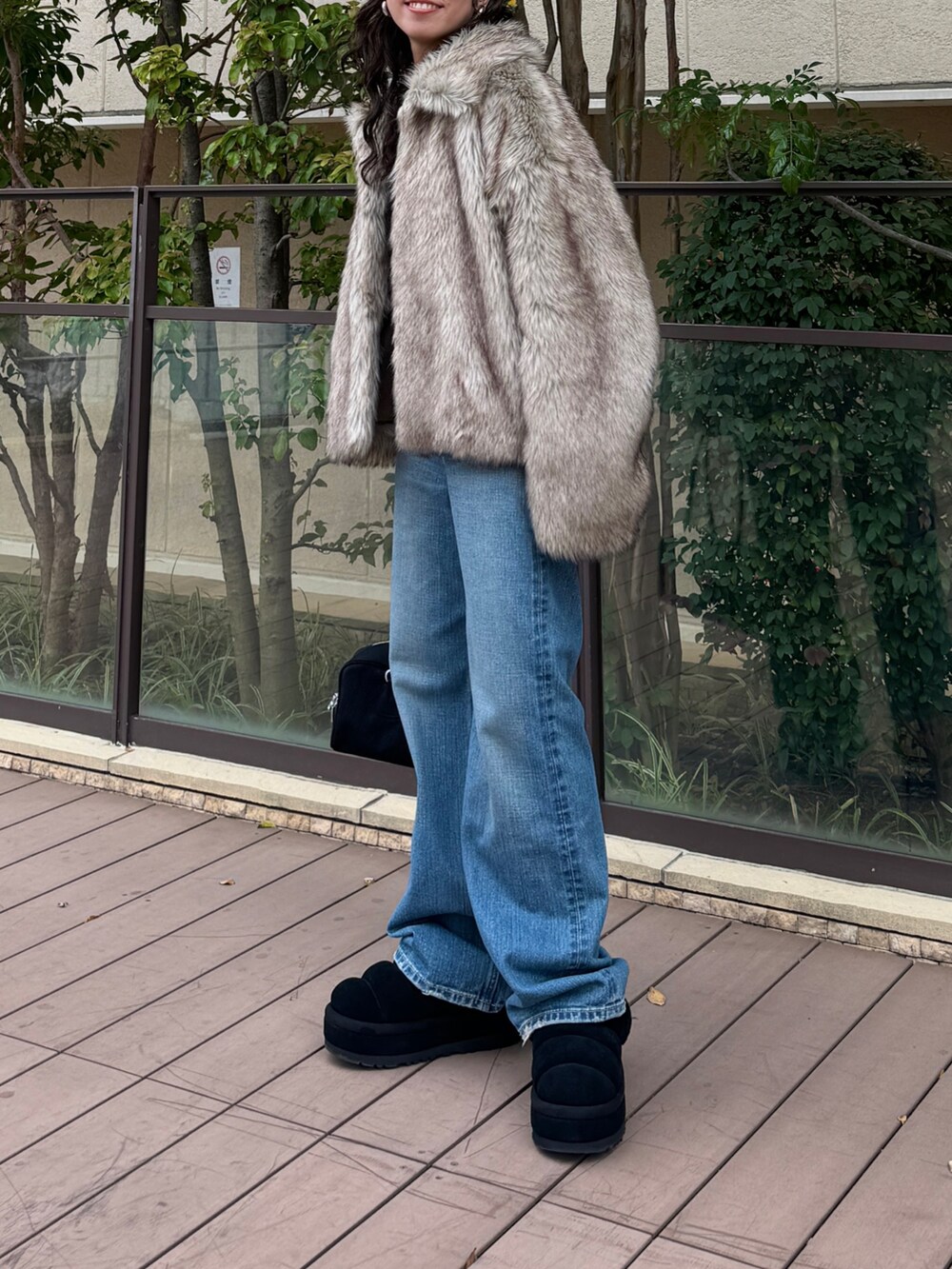 ベージュ系のその他アウター、ブルー系のデニムパンツ、ブラック系のハンドバッグを着用したレディースの秋コーディネートの2枚目の写真