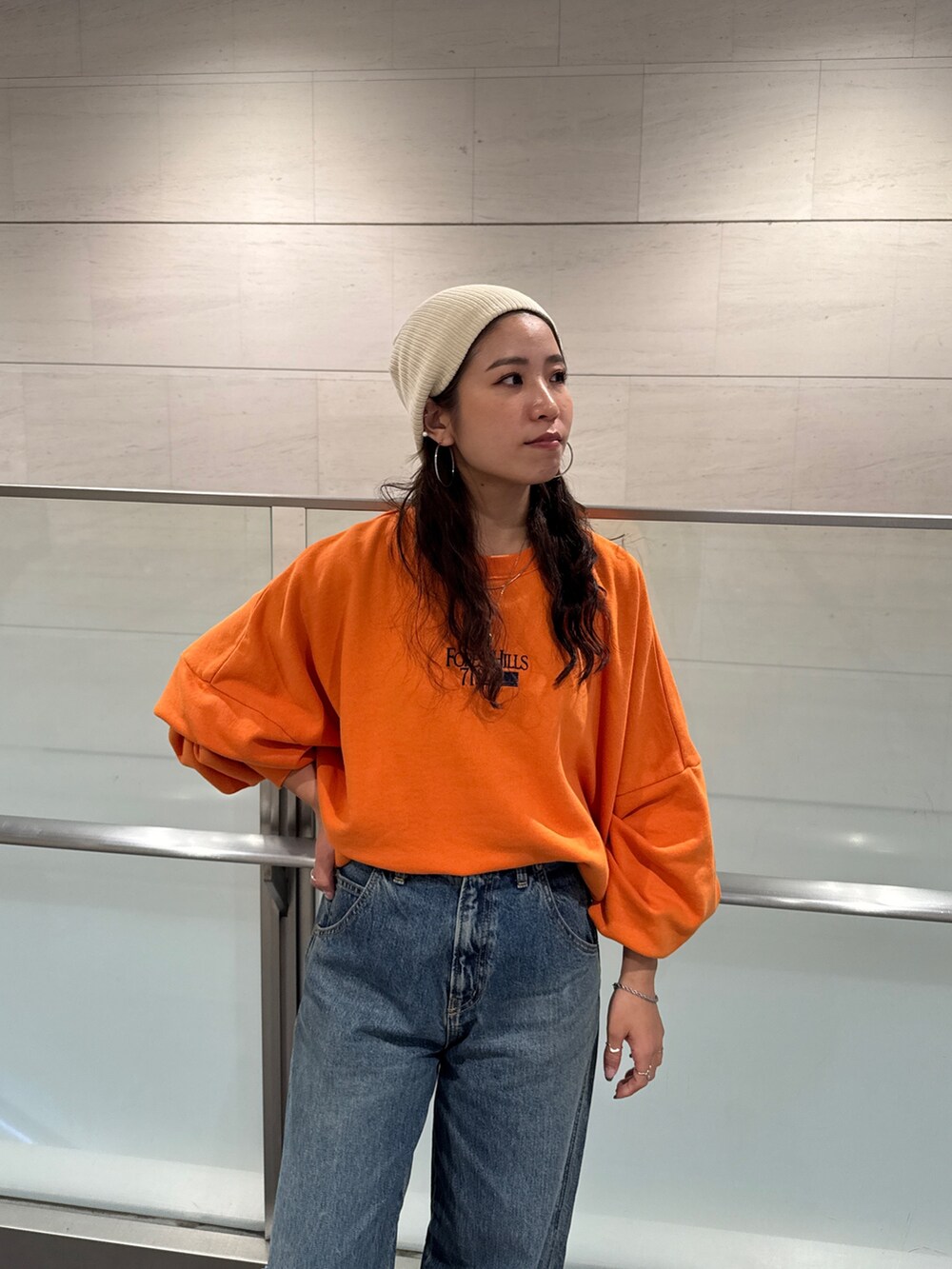 ブルー系のデニムパンツ、オレンジ系のスウェットを着用したレディースの冬コーディネートの7枚目の写真