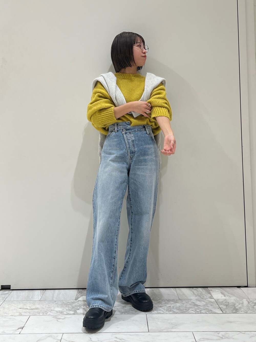 ブルー系のデニムパンツ、イエロー系のニット/セーター、グレー系のスウェットを着用したレディースの冬コーディネートの2枚目の写真