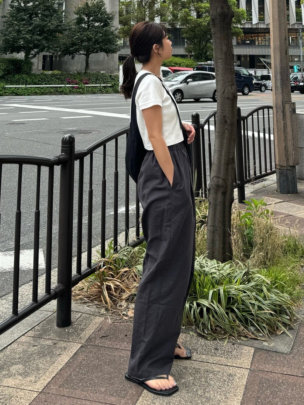 ホワイト系のTシャツ/カットソー、グレー系のその他パンツ、ブラック系のサンダルを着用したレディースの春コーディネートの5枚目の写真