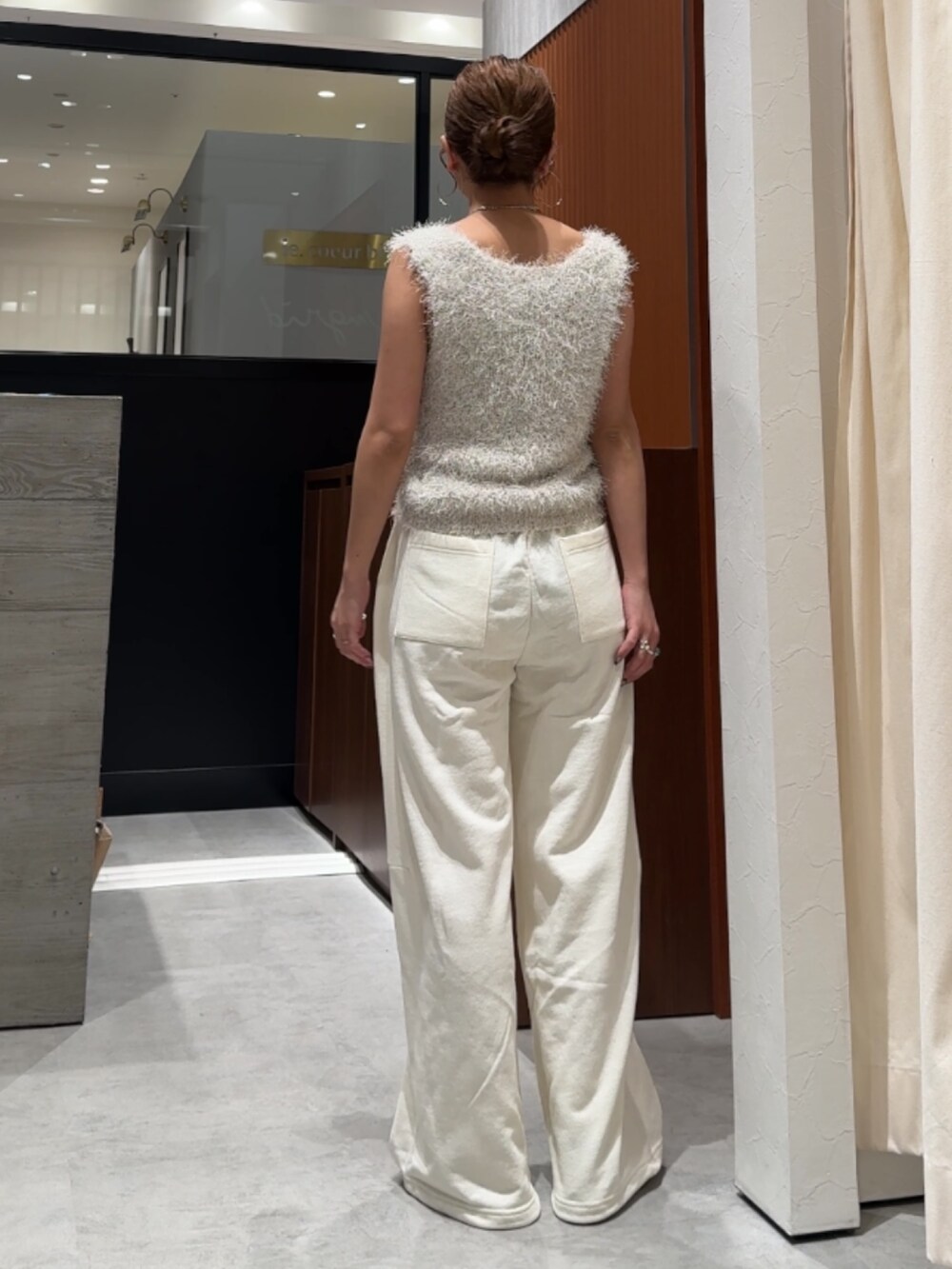 ホワイト系のスウェットパンツ、ホワイト系のベストを着用したレディースの春コーディネートの4枚目の写真