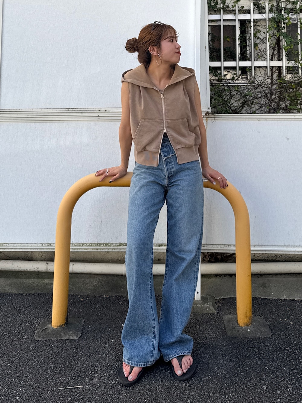 ベージュ系のパーカー、ブルー系のデニムパンツを着用したレディースの夏コーディネートの5枚目の写真