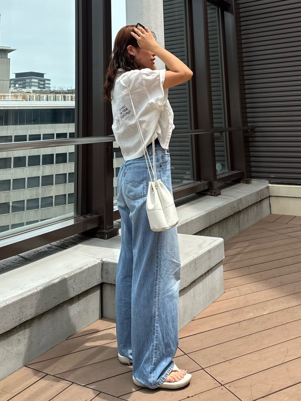 ブルー系のデニムパンツ、グレー系のTシャツ/カットソー、ホワイト系のシャツ/ブラウスを着用したレディースの夏コーディネートの4枚目の写真