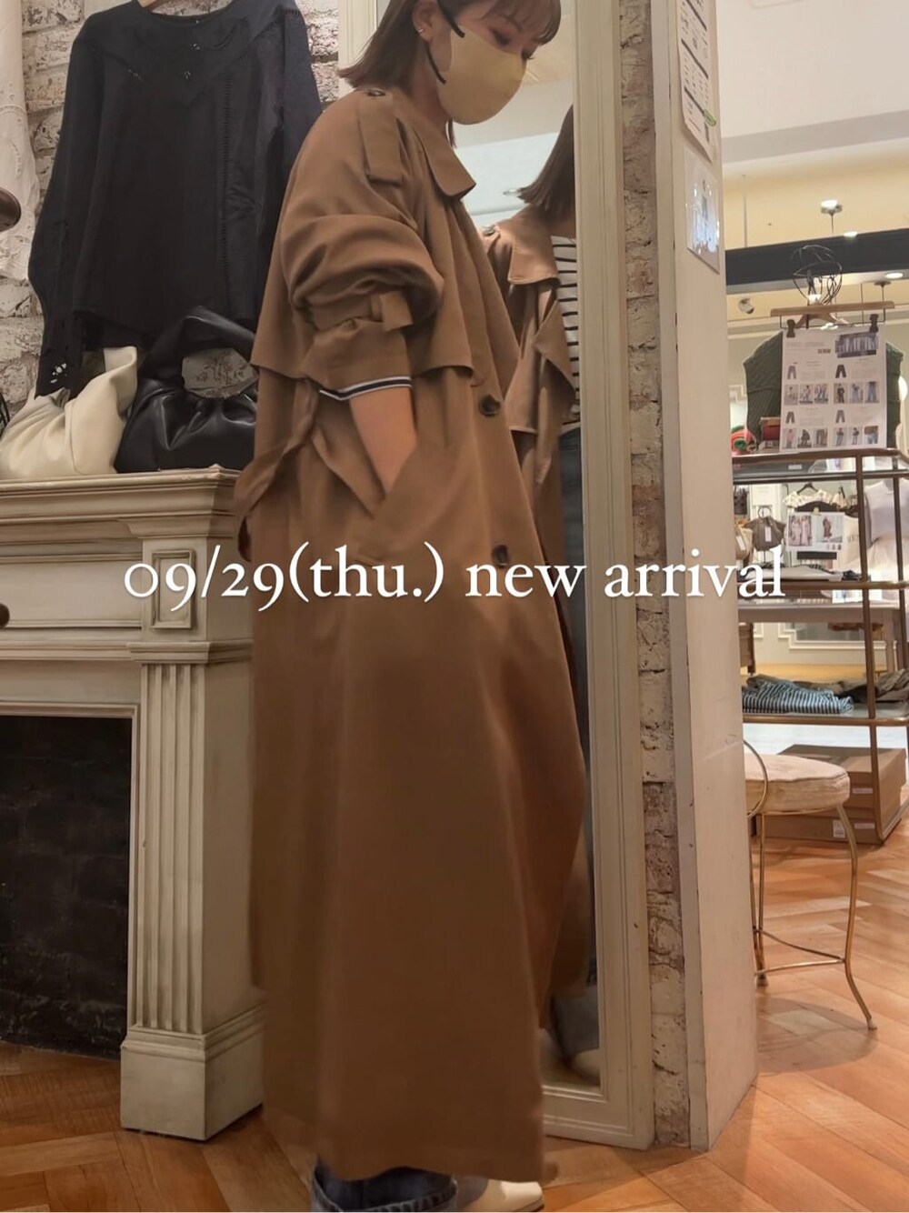 ブルー系のTシャツ/カットソー、イエロー系のトレンチコート、ホワイト系のブーツを着用したレディースの秋コーディネートの6枚目の写真