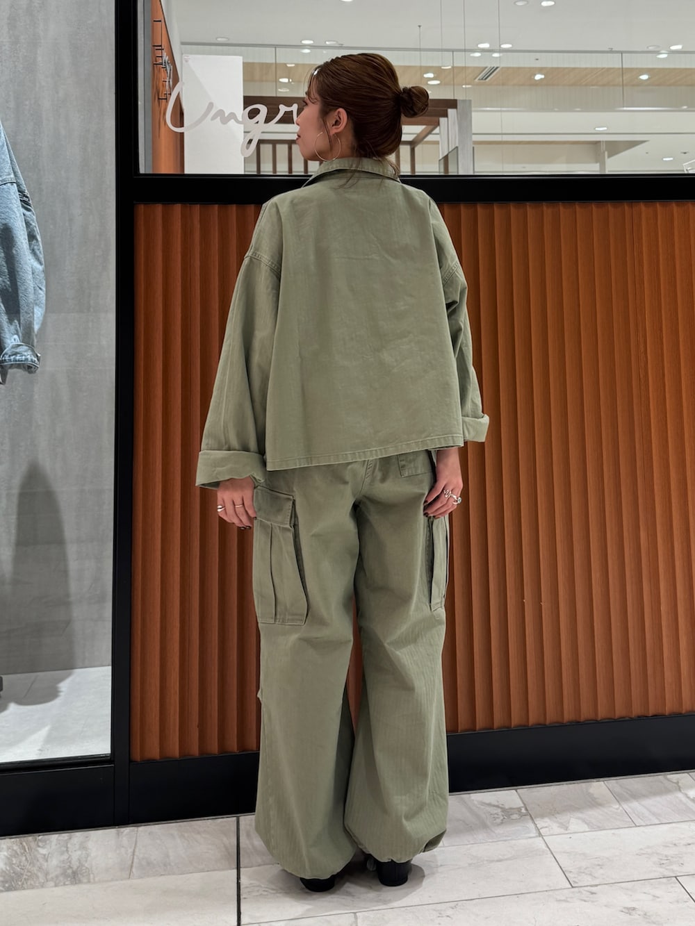 グリーン系のミリタリージャケット、ブラック系のキャミソール、グリーン系のその他パンツを着用したレディースの春コーディネートの4枚目の写真