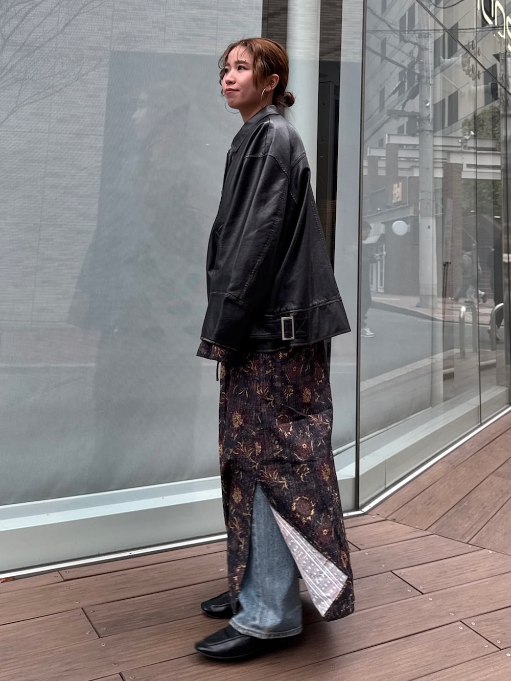 ブラック系のブルゾン、ブラック系のワンピース、ブルー系のデニムパンツを着用したレディースの冬コーディネートの7枚目の写真