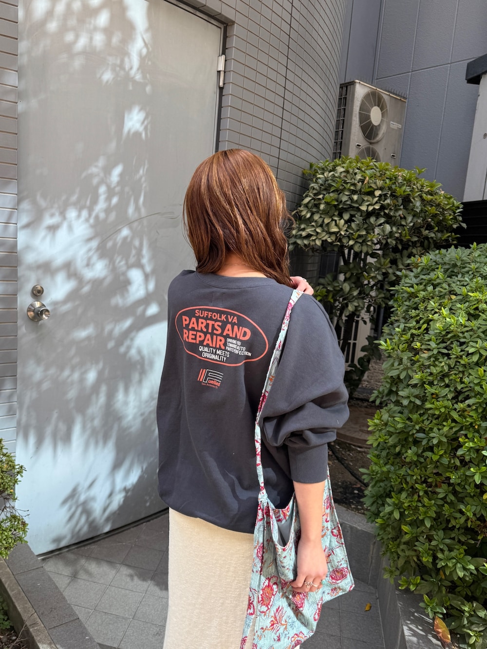 グリーン系のショルダーバッグ、グレー系のスウェット、ホワイト系のスカートを着用したレディースの冬コーディネートの8枚目の写真