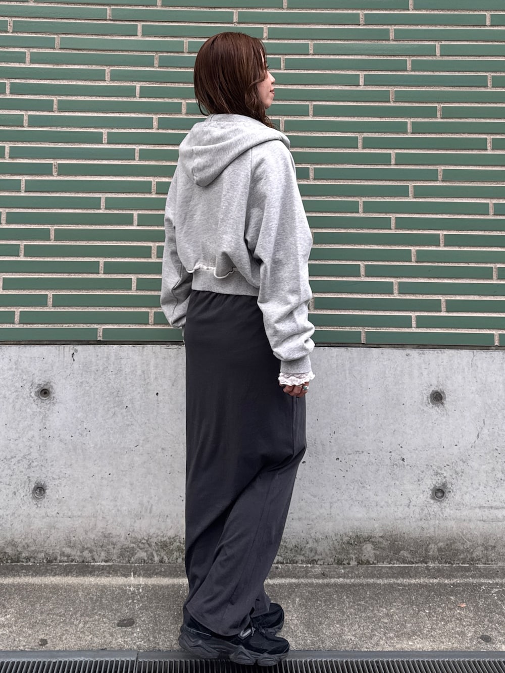 グレー系のパーカー、ホワイト系のTシャツ/カットソー、グレー系のスカートを着用したレディースの冬コーディネートの2枚目の写真