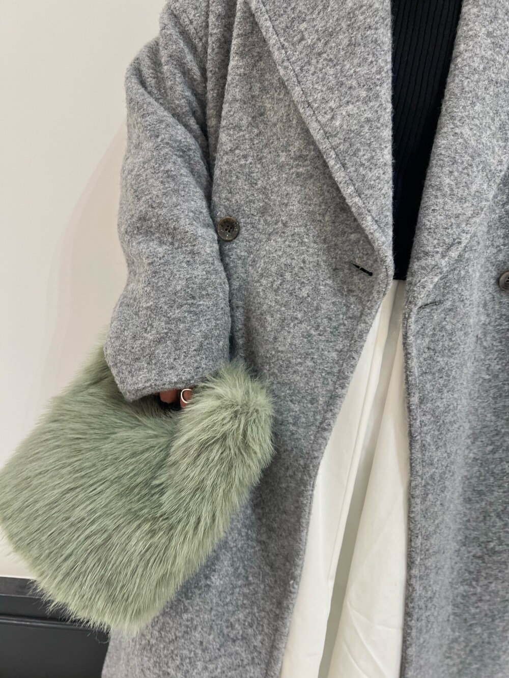 ブラウン系のブーツ、ブラック系のワンピース、グレー系のチェスターコートを着用したレディースの冬コーディネートの8枚目の写真