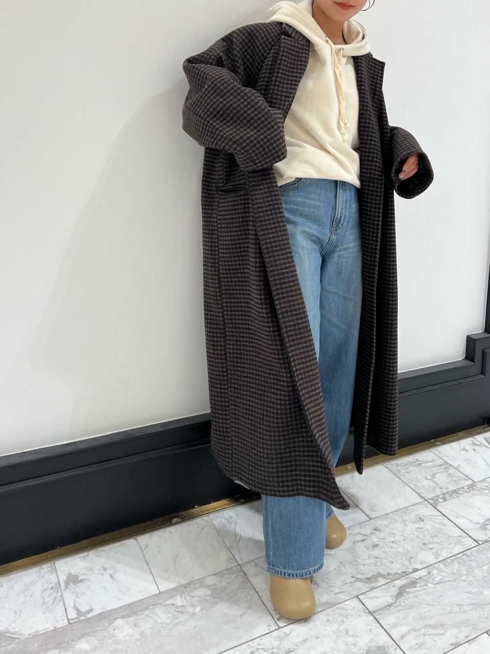 ベージュ系のブーツ、ブルー系のデニムパンツ、その他のチェスターコートを着用したレディースの冬コーディネートの6枚目の写真