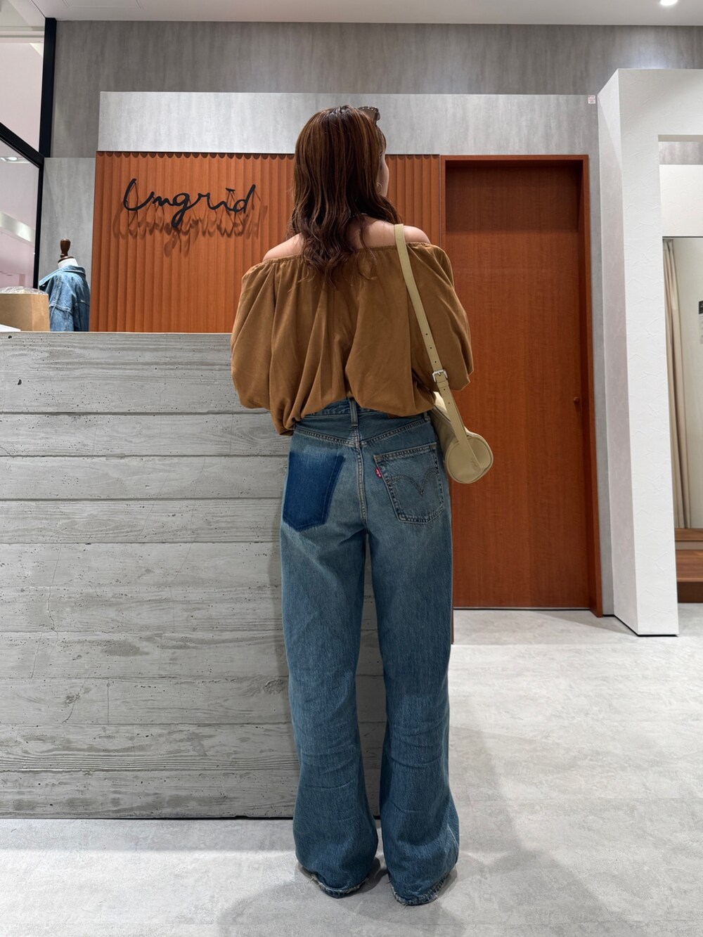 ブルー系のデニムパンツ、イエロー系のシャツ/ブラウス、ブラウン系のサングラスを着用したレディースの夏コーディネートの4枚目の写真