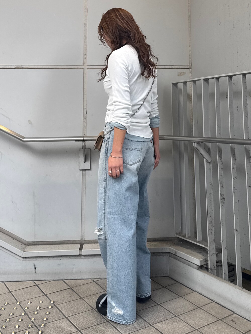 ブルー系のデニムパンツ、ホワイト系のTシャツ/カットソー、ブルー系のTシャツ/カットソーを着用したレディースの冬コーディネートの3枚目の写真