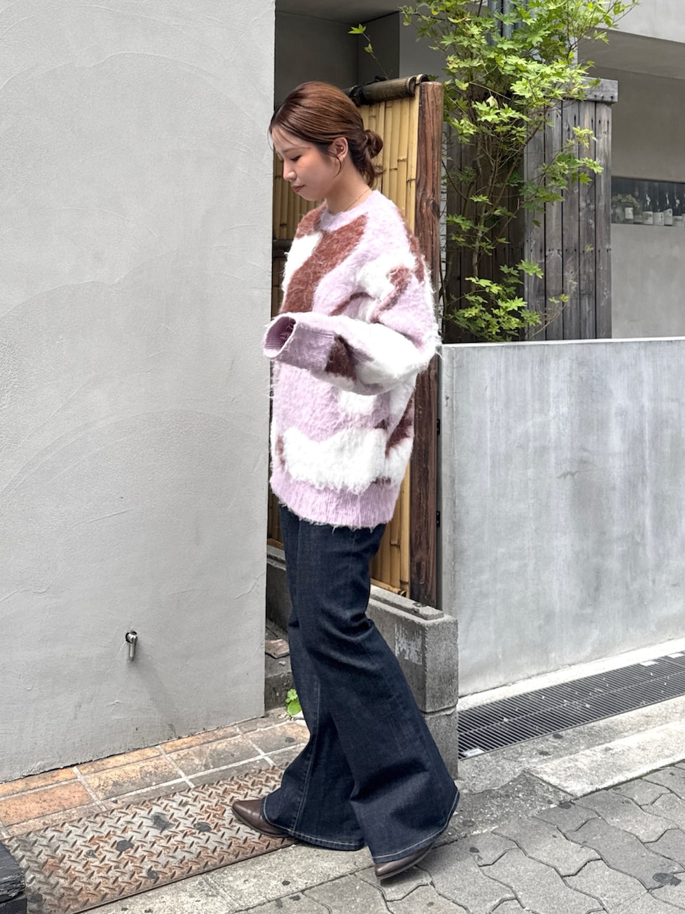 ブルー系のデニムパンツ、ブラウン系のブーツ、ピンク系のニット/セーターを着用したレディースの秋コーディネートの4枚目の写真