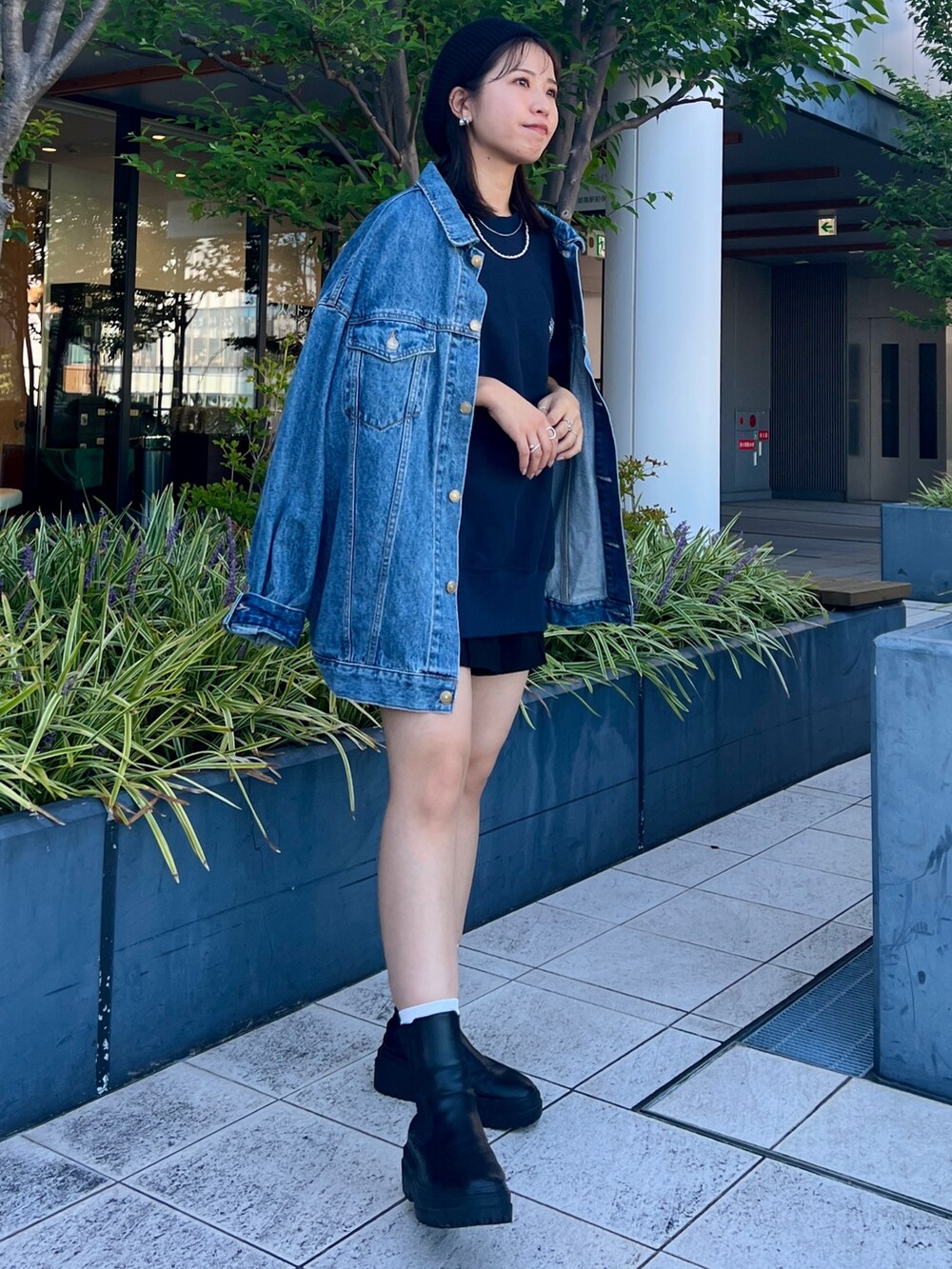 ブルー系のスウェット、ブルー系のデニムジャケット、ブラック系のハンチング/ベレー帽を着用したレディースの秋コーディネートの4枚目の写真