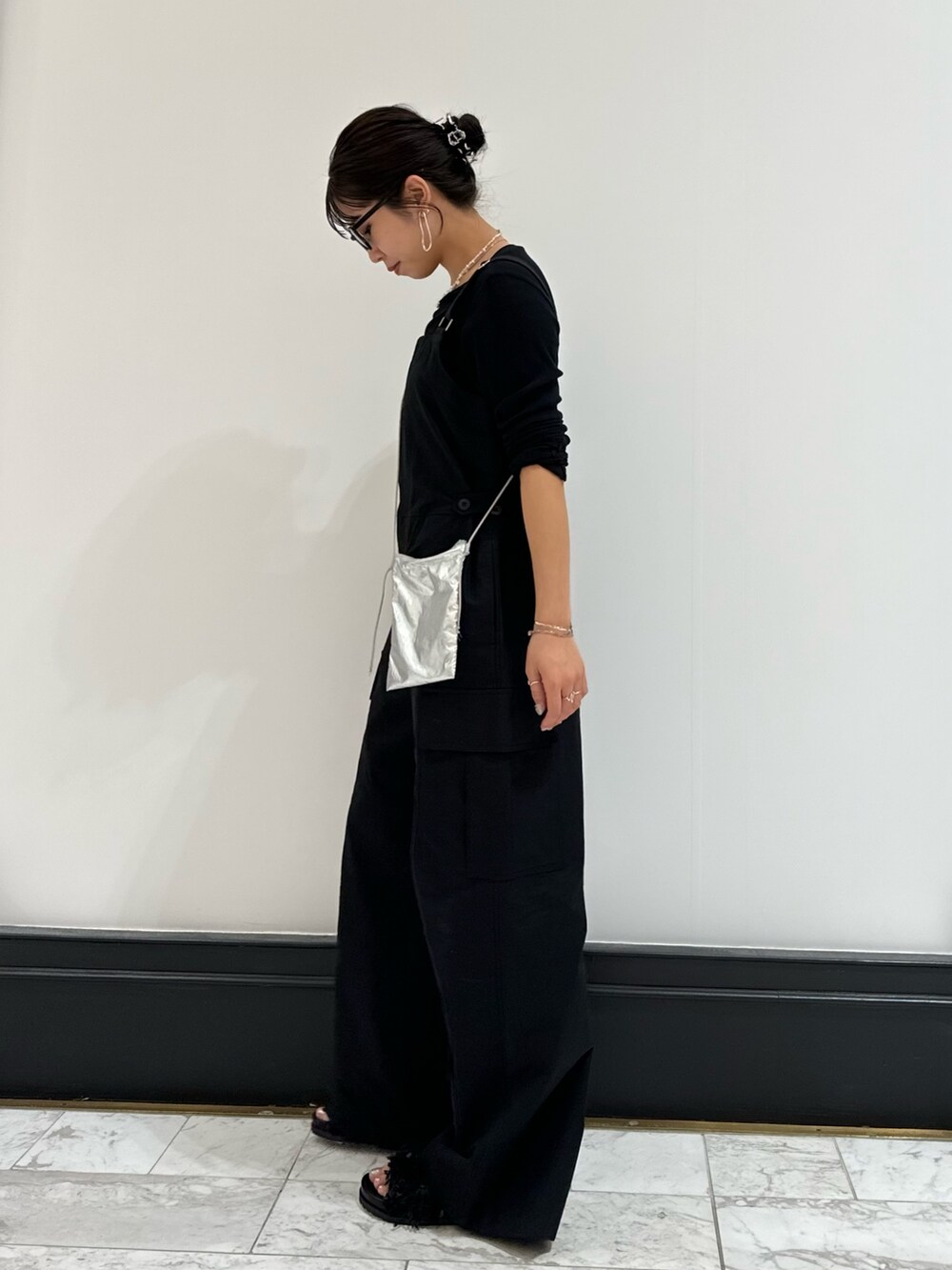 ブラック系のつなぎ/オールインワン、ブラック系のTシャツ/カットソー、ブラック系のサンダルを着用したレディースの冬コーディネートの6枚目の写真