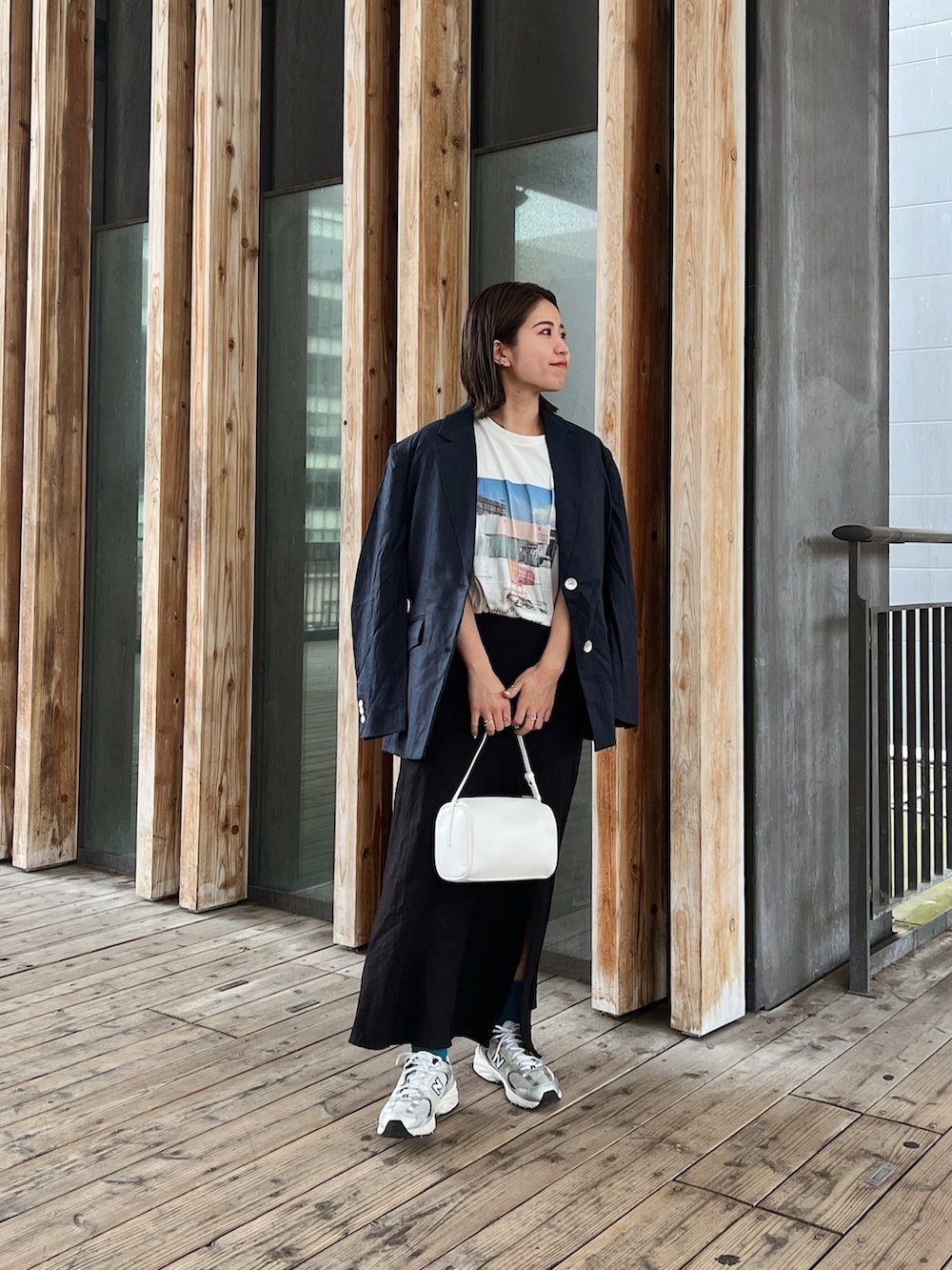 ブルー系のテーラードジャケット、ブラック系のスカート、ホワイト系のTシャツ/カットソーを着用したレディースの春コーディネートの3枚目の写真